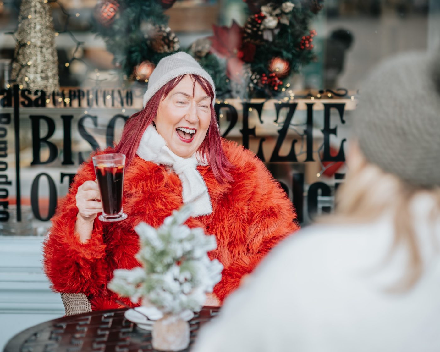Woman wearing festive outfit enjoying a glass of mulled wine